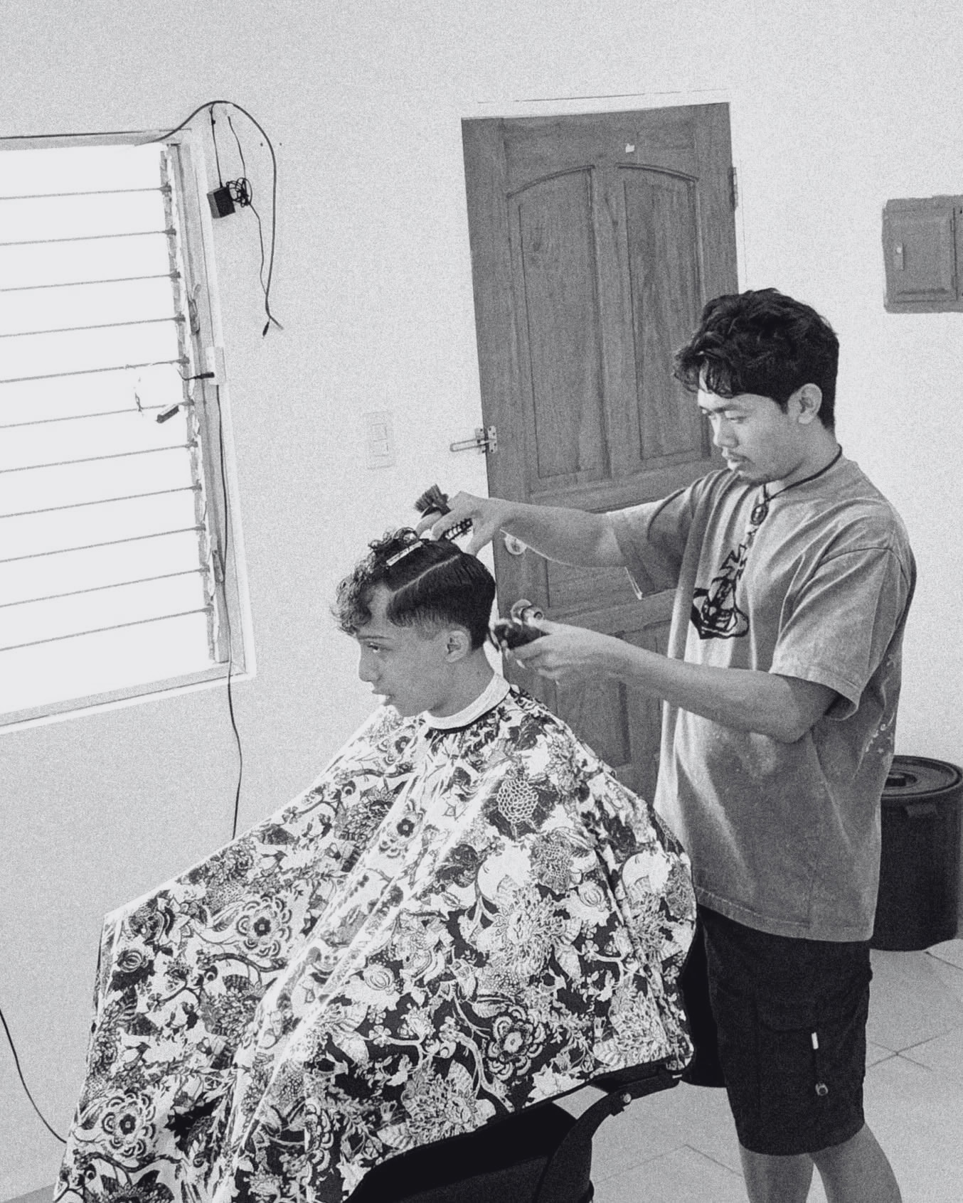 Barber cutting hair at Astang Barbero